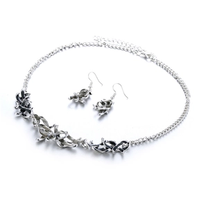 Detail of vintage silver leaf jewelry set with necklace and earrings in enamel finish