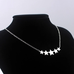 Polished stainless steel pentagram star necklace for women on black display stand