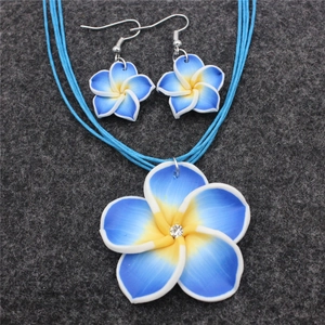 Detailaufnahme des blauen Plumeria-Schmucksets aus Ton mit Halskette und Ohrringen