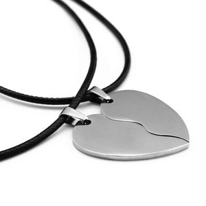 Polished stainless steel heart puzzle pendant necklace set for couples on a white background