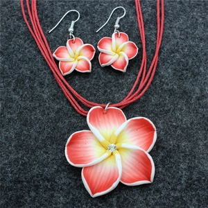 Nahaufnahme von Schmuckset mit roten Farbverlauf-Frangipani-Blüten und Halsketten