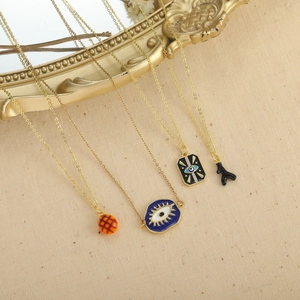 Vintage gold layered necklace set with blue evil eye enamel charms on linen fabric