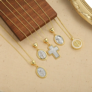 Religious golden cross and Saint Jude pendant necklaces on beige vintage background