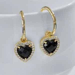 Close-up of golden bamboo texture hoop earrings with black heart gemstone and crystals