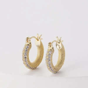 Détail des boucles d'oreilles en C plaquées or 18 carats avec texture martelée et zircons