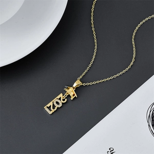 Golden 2021 graduation necklace with mortarboard charm and sparkling zircon on black background