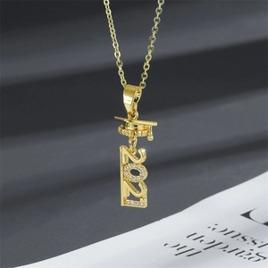 Macro detail of gold graduation necklace with Class of 2021 cap pendant and micro-pavé crystals