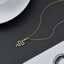 Detail of elegant gold snake pendant necklace with a minimalist wavy serpentine design