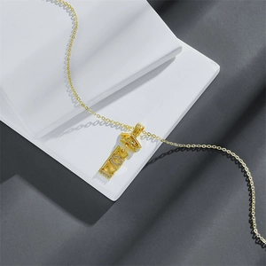 Macro shot of gold graduation necklace with 2024 pendant and cubic zirconia details