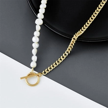 Detail of gold chain necklace with white baroque pearls and a toggle clasp design