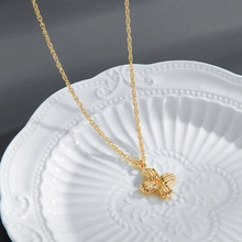 Detail of vintage gold wave chain with a textured cross pendant on a white plate