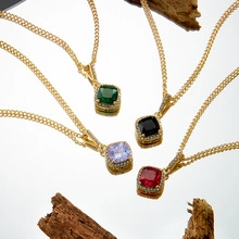 Detail of four colorful gemstone pendant necklaces on golden flat Cuban chains