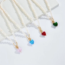 Detail of four pearl necklaces with heart pendants in pink, blue, red and green colors