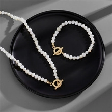 French style pearl necklace and bracelet set with golden OT clasps on black tray