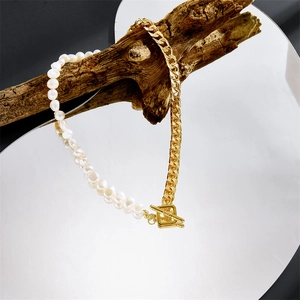 Collier en perles d'eau douce avec chaîne plaquée or et fermoir OT sur une branche