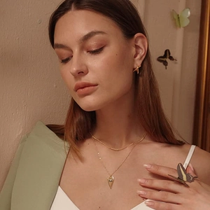 Double-layered gold necklace with evil eye pendant and matching stud earrings for women
