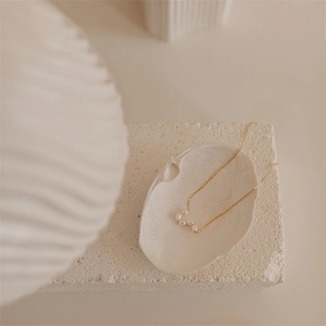 Minimalist freshwater baroque pearl necklace with delicate 14K gold plated chain on a shell tray