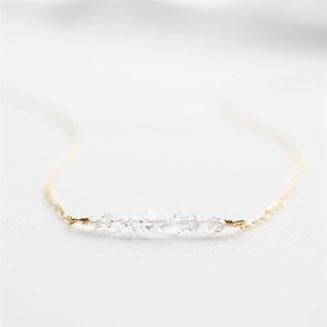Macro detail of natural clear quartz crystals hand-wrapped on a 14K gold plated chain