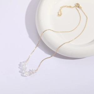 Detail of clear white crystal pendant necklace on 14K gold-plated chain with lobster clasp
