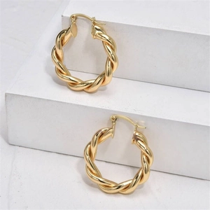 Élégantes boucles d'oreilles créoles torsadées dorées avec un design en forme de C