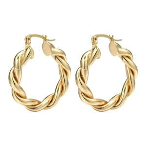 Boucles d'oreilles créoles torsadées dorées avec motif en spirale sur fond blanc