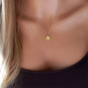 Collier avec pendentif pièce étoile plaqué or 14K porté par un modèle féminin