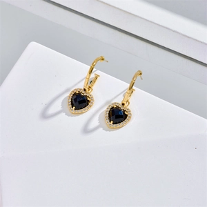 Fashionable black heart earrings with gold plating and cubic zirconia halo on white steps