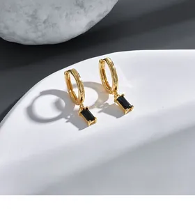 Close-up of gold plated hoop earrings featuring rectangle black zircon stone pendants