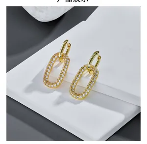 Dettaglio di orecchini a doppio ovale in oro 14k con micro-set di pietre in zirconite