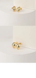 Macro detail of gold-plated oval stud earrings with white gemstones and S925 hallmark