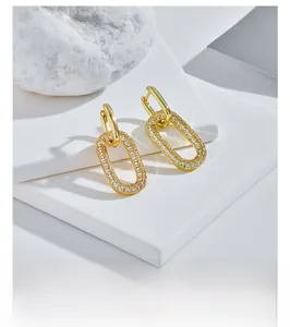 Dettaglio macro di orecchini a cerchio ovali placcati oro 14k con pavé di zirconi
