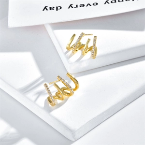 Detail of 18k gold plated four-row claw earrings with sparkling white zircon stones