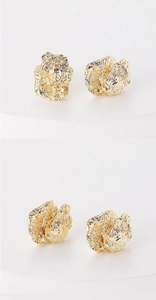 Detail view of gold-plated brass stud earrings with a unique hammered lava texture