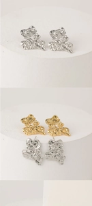 Detailed macro view of irregular crumpled gold and silver plated textured earrings
