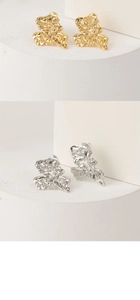 Detail of irregular molten metal earrings with mirror polished finish in gold and silver