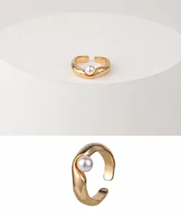 Detail eines vergoldeten verstellbaren Rings mit Perle und gewelltem Design