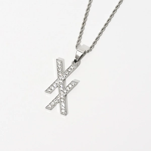 Macro shot of silver rope chain with double X letter pendant featuring pavé cubic zirconia
