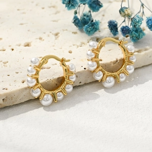 Detail of 14k gold plated hoop earrings with natural freshwater pearls on stone base