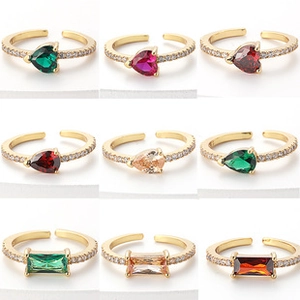 Collage of adjustable gold brass rings with colorful heart and pear shaped crystals