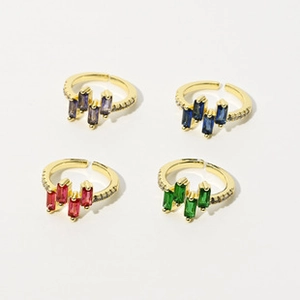 Detailed macro shot of four adjustable brass rings with gold plating and colorful crystals