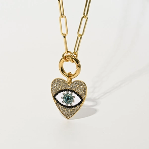 Golden paperclip chain necklace with heart-shaped evil eye pendant and zircon crystals