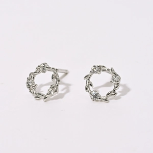 Détails macro des boucles d'oreilles couronne de fleurs avec zircons micro-sertis