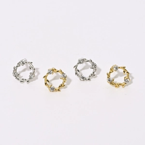 Détails macro de boucles d'oreilles couronne de fleurs en or et argent avec zircons brillants