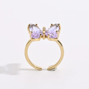 Detailed macro shot of a gold butterfly ring with purple crystals and sparkling zircon stones