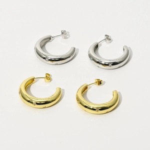 Détails de boucles d'oreilles créoles en C dorées et argentées avec zircons étoilés