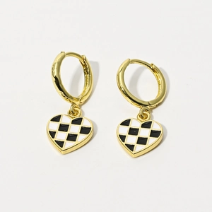 Golden heart-shaped checkerboard drop earrings with black and white enamel finish