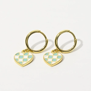 Detailed close-up of mint green and white checkerboard heart earrings with gold hoop closure