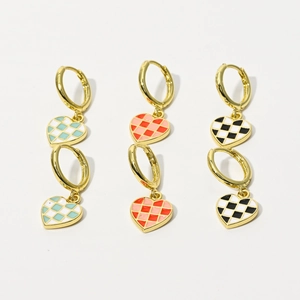 Close-up of three checkered heart earrings in mint green, orange-red, and black-white enamel