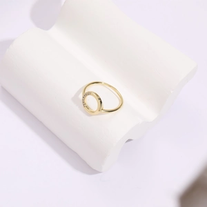 Detailed close-up of 14k gold plated ring with round zircon stones on a white pedestal