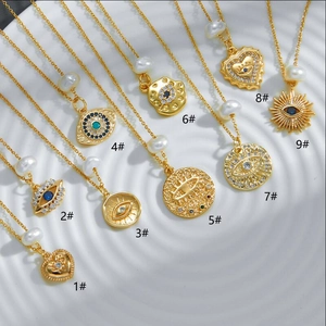 Collection of 14k gold plated necklaces with evil eye and pearl pendants on a white plate